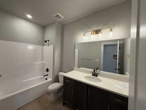 Bathroom with dark wood finished floors, vanity, shower / bathtub combination, and recessed lighting