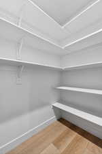 Spacious closet featuring light wood-style flooring