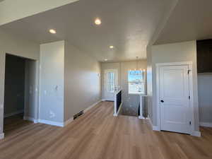Unfurnished dining area with recessed lighting, light wood finished floors, a chandelier, and a textured ceiling