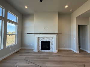 Unfurnished living room featuring a fireplace, recessed lighting, light wood finished floors, and a ceiling fan