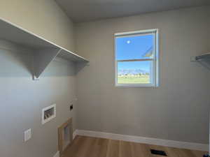 Laundry area featuring light wood-style flooring, electric dryer hookup, hookup for a washing machine, and a mountain view