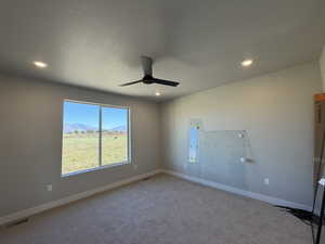 Carpeted empty room with a mountain view, recessed lighting, a ceiling fan, and a textured ceiling