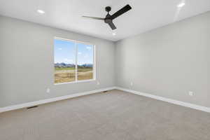 Carpeted spare room featuring ceiling fan and recessed lighting