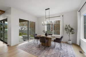Dining space featuring light wood-type flooring and a chandelier