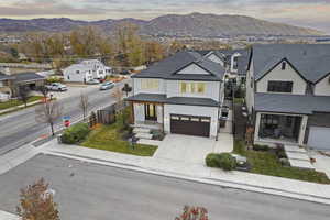 Modern inspired farmhouse with a mountain view, a residential view, concrete driveway, a garage, and a gate