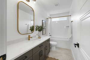 Full bath with vanity, shower / bath combo, and light tile patterned floors