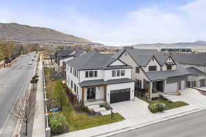 View of front facade with covered porch, driveway, a mountain view, and a residential view