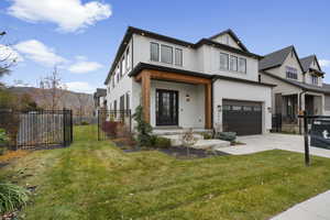 Modern inspired farmhouse featuring a porch, an attached garage, brick siding, concrete driveway, and a gate