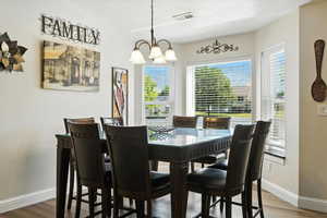 Dining space with a chandelier and wood finished floors