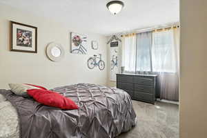 Bedroom featuring light carpet and a textured ceiling