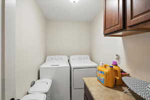 Laundry room with washer and clothes dryer and cabinet space
