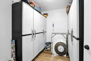 Pantry/Storage room with light wood finished floors and a textured ceiling