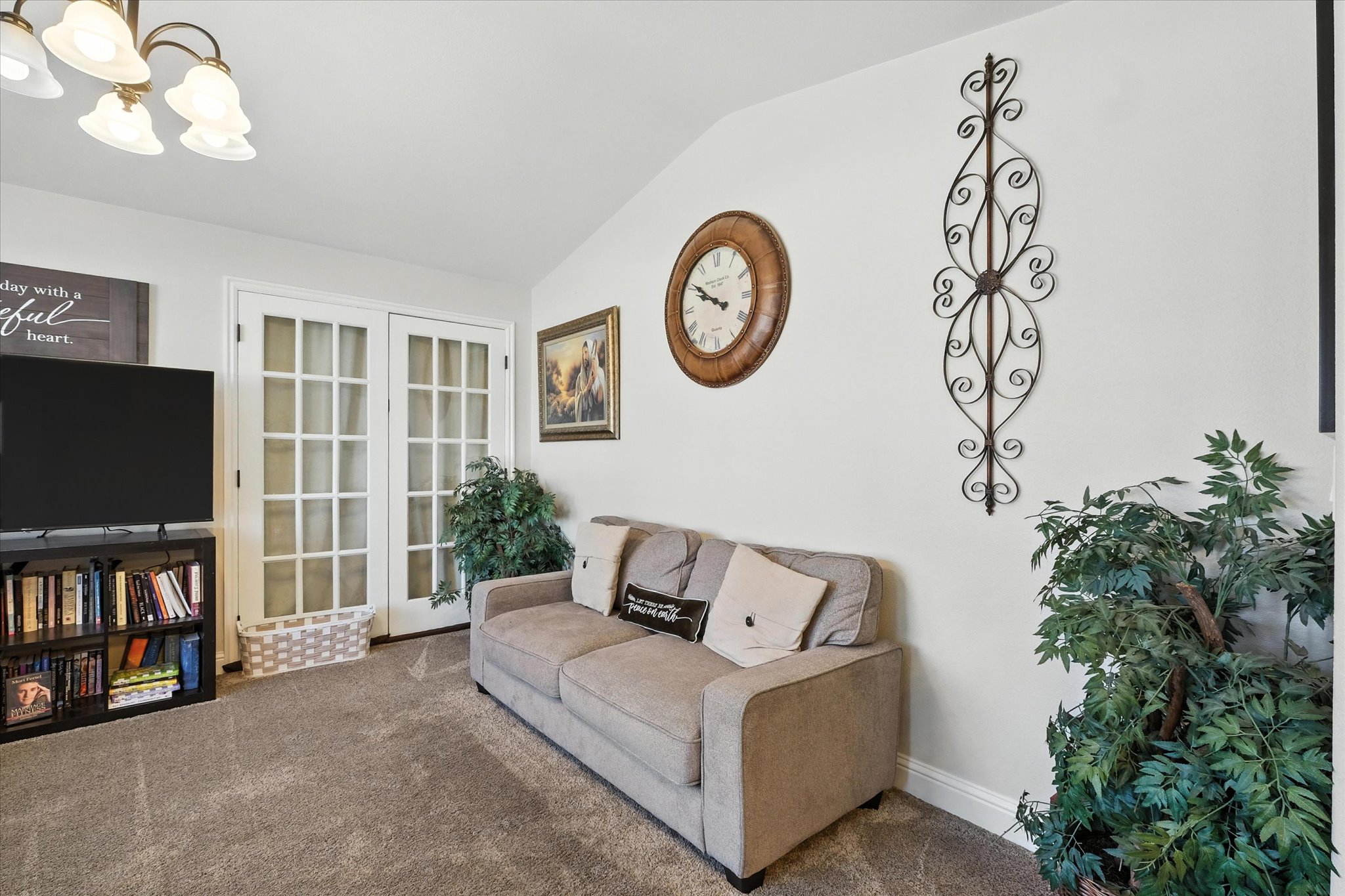 Carpeted living room with a chandelier and lofted ceiling