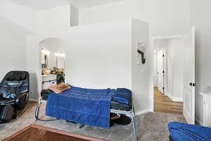 Bedroom featuring arched walkways and carpet