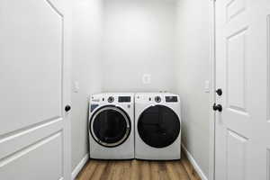 Laundry area featuring washer and dryer and wood finished floors