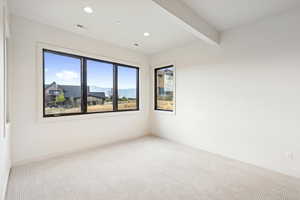 Empty room with carpet flooring, beam ceiling, a mountain view, and recessed lighting