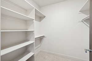Walk in closet featuring light colored carpet