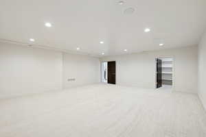 Basement featuring recessed lighting and light carpet
