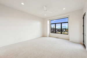 Carpeted spare room featuring a mountain view, recessed lighting, and ceiling fan