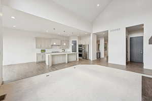 Unfurnished living room with wood tiled floors, high vaulted ceiling, and recessed lighting