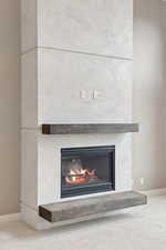 Detailed view of carpet flooring and a glass covered fireplace