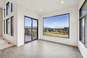 Spare room with a mountain view, light wood finished floors, plenty of natural light, and recessed lighting