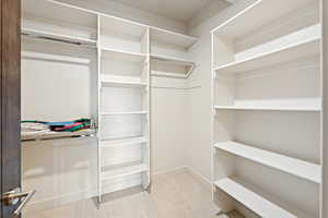 Walk in closet featuring light colored carpet