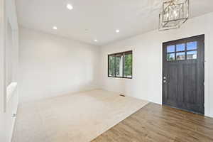 Foyer featuring recessed lighting, wood finish floors, and a chandelier