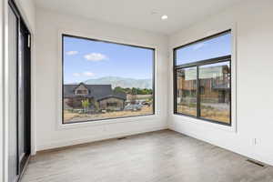 Empty room featuring a mountain view, light wood-style flooring, and recessed lighting