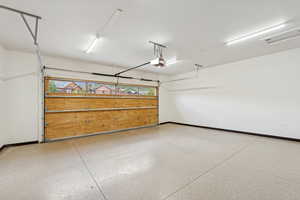 Garage with baseboards and a garage door opener