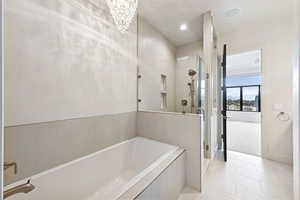 Full bathroom with tile patterned flooring, a shower stall, a garden tub, recessed lighting, and a chandelier