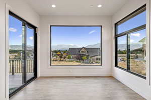 Spare room featuring a mountain view, light wood-style flooring, and recessed lighting