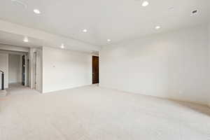 Empty room with light carpet and recessed lighting