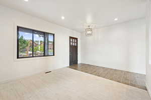Unfurnished room featuring recessed lighting, carpet flooring, a chandelier, and wood finished floors