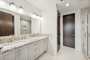 Full bathroom with double vanity, a shower stall, light tile patterned floors, and recessed lighting