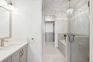 Full bathroom with a bath, vanity, light tile patterned flooring, a shower stall, and a chandelier