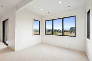 Unfurnished room with light colored carpet, a mountain view, beamed ceiling, and recessed lighting