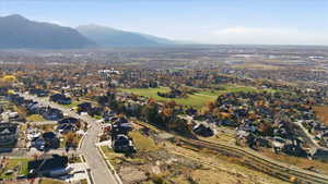 Aerial view of property and surrounding area with a mountainous background and nearby suburban area
