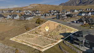 Aerial view of property's location with nearby suburban area and a mountainous background