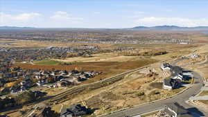 Aerial view of property and surrounding area with nearby suburban area and a mountain backdrop