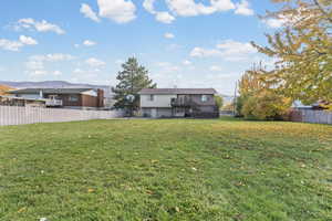 Back of property featuring a fenced backyard, stairs, and a mountain view