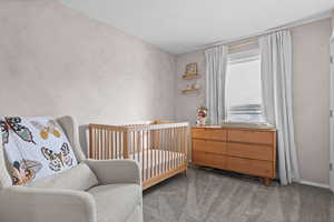 Bedroom featuring carpet floors and a crib