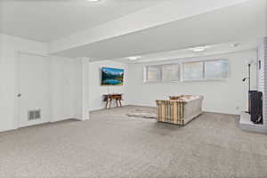 Additional living space with light colored carpet and a textured ceiling