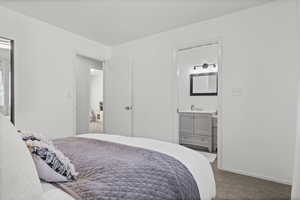 Carpeted bedroom with connected bathroom and baseboards