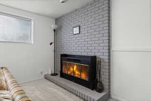 Detailed view of carpet floors, a fireplace, and a textured ceiling