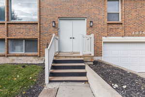 Doorway to property featuring brick siding