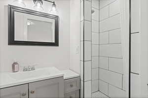 Bathroom featuring a shower stall and vanity