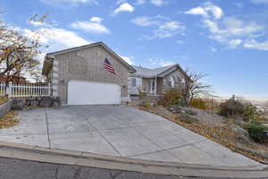 Single story home with brick siding, concrete driveway, and a garage