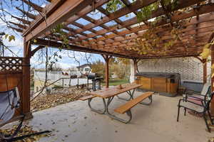 View of patio featuring a hot tub, a grill, and a pergola