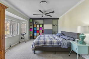 Bedroom featuring carpet, ornamental molding, and a ceiling fan